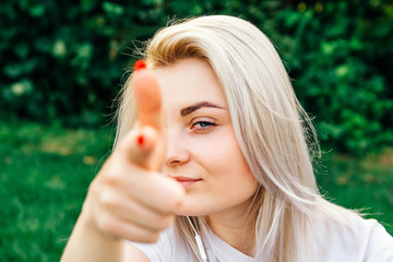 Naklejka premium Portrait of beautiful blonde girl smiling, making shot of fingers in camera with happy face. Creativity and photography concept