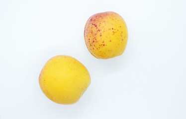 Delicious juicy apricots are located on a white background