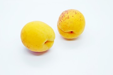 Delicious juicy apricots are located on a white background