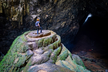 Caver on the Wedding Cake in first doline, and view on second doline in the distance in Son Doong...