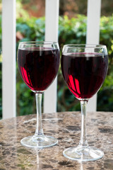 Two glasses of red wine on a table. Outdoor