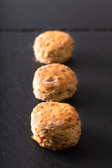 Food concept Fresh baked Homemade buttery, salty Ham and cheese scones on black background.