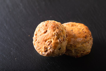 Food concept Fresh baked Homemade buttery, salty Ham and cheese scones on black background.