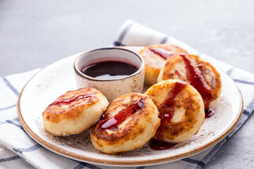 Curd pancakes with strawberry sauce on a plate