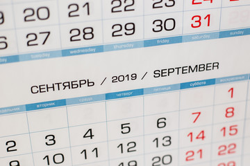 Close-up calendar for the month of September 2019. Hello September. Hello, Autumn. Russian-English calendar on a blue background