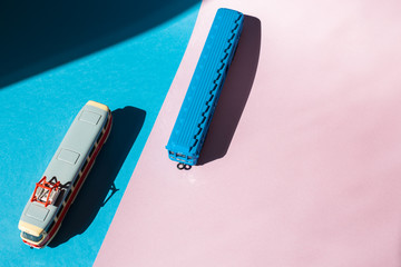 Models of a Russian metro car and tram on a pink background with sunlight. Russian transport. Toy models