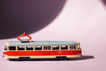 Model of a Russian tram on a pink background with sunlight. Russian transport. Toy model