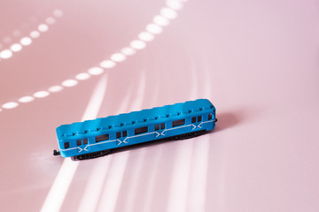 Model of a Russian metro car on a pink background with sunlight. Russian transport. Toy model