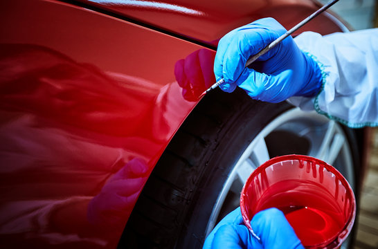 Tinting defects of a red car paint on the service
