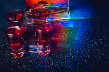 Shots for vodka in a nightclub. Dark party photo