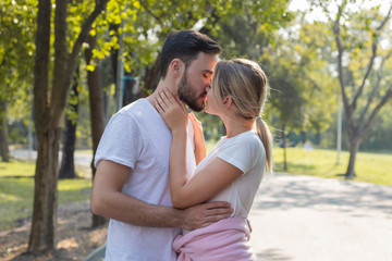 Couples standing kiss and hugging in the park.