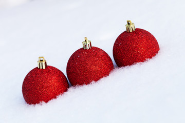 Bright balls on a clean pure snow for natural winter background. New year composition. Shallow...