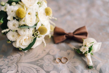 Wedding accessories bride and groom. Wedding bouquet, groom’s boutonniere, rings, floristry and decorations