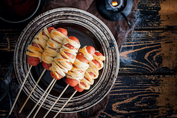 Sausages wrapped in dough in the form of a mummy for decorating the table for the holiday Halloween...