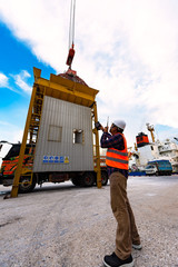 foreman stevedore working in yard terminal of the port checking safety equipments readiness for...