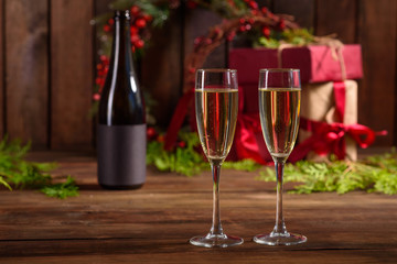 Christmas holiday table with glasses and a bottle of wine of champagne. Eve of new year, preparation and laying of a wooden holiday table