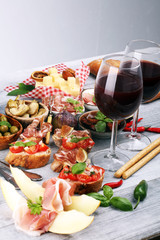 Italian antipasti wine snacks set. Cheese variety, Mediterranean olives, Prosciutto di Parma, tomatoes, artichokes
