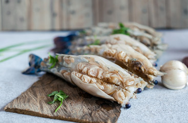 Raw peeled big prawn on wooden cutting board with ingredients.