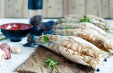 Raw peeled big prawn on wooden cutting board with ingredients.