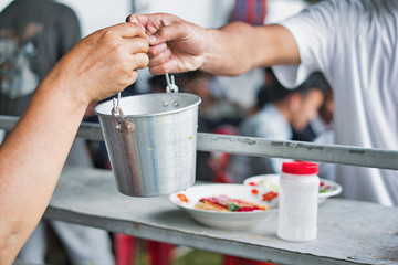 Close up of hand giving, taking, preparing food to hands of a beggar. Food donation concept.