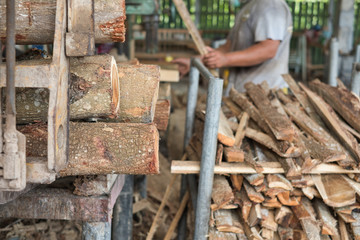 Pile of logs and woods in wood factory waiting for further cutting process.