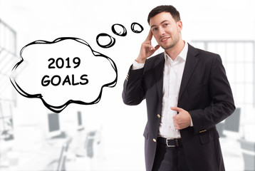 Business, technology, internet and network concept. The young businessman comes up with the keyword: 2019 goals