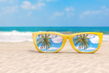 Fototapeta na wymiar Summer Vacation Concept. Blue Skies with Palm Reflecting in Modern Yellow Sunglasses on an Ocean Deserted Coast. 3d Rendering