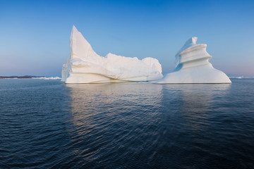 Photogenic and intricate iceberg under an interesting and blue sky during sunset. Effect of global...