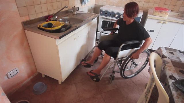 disabled girl on wheel chair in everyday life in the kitchen