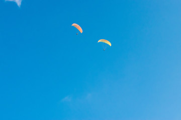 Two paragliders flying on the sky