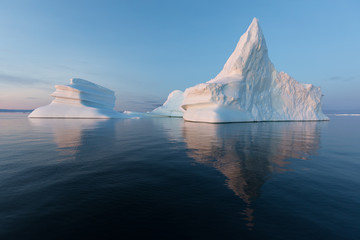 Photogenic and intricate iceberg under an interesting and blue sky during sunset. Effect of global...