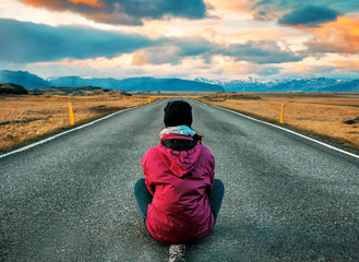 girl sitting in the middle of the road