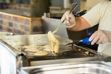 The cook prepares fritters on the stove. Concept - Traditional Cuisine