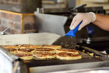 The cook prepares fritters on the stove. Concept - Traditional Cuisine