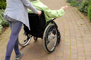 Obraz premium woman in a disabled person's park driving an elderly woman, rear view, horizon shifted to give a dynamic picture