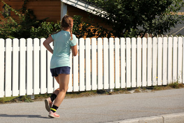 WALLDAL, NORWAY - July 2019: girl running down the street in sportswear and shoes, concept of sport and healthy lifestyle