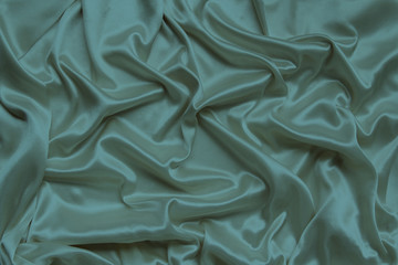 beautiful satin draped with soft folds fabric, silk cloth background, close-up, copy space