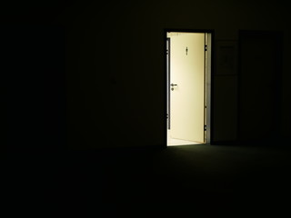 Tür zur beleuchteten Herrentoilette bei Nacht