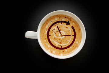 white wide cup of coffee, cappuccino with a clock pattern on a black background with vignette, top view, save space, close-up, time concept