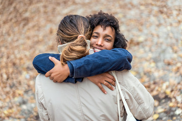 Fototapeta premium guy with an african american girl in love in autumn park walk at sunset