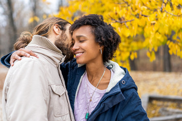 guy with an african american girl in love in autumn park walk at sunset