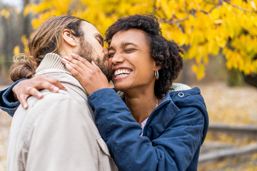 guy with an african american girl in love in autumn park walk at sunset