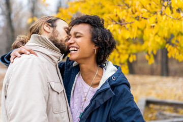 guy with an african american girl in love in autumn park walk at sunset