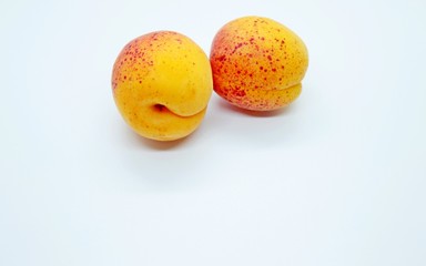Delicious juicy apricots are located on a white background