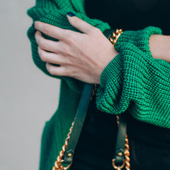 Close-up fragment of a female woolen sweater. Red-haired girl in a green cardigan. Green knitted sweater. fashionably dressed girl.