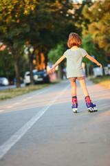 Little girl successfully learns to roller skate. Young girl learns to rollerblade.