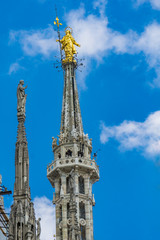 Fototapeta na wymiar Statue of the Virgin Mary on top of Milan Cathedral (Duomo di Milano) in Italy