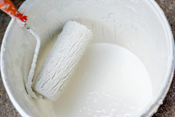 white roller brush in Paint can
