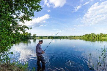Angler catching the fish in the lake