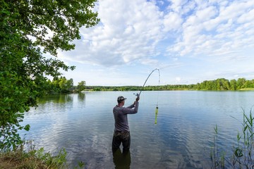 Angler catching the fish in the lake 